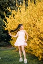 Young woman has enjoy and relaxes near blooming forsythia bushes