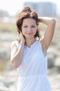 Young woman in white dress poses with hands on head Royalty Free Stock Photo