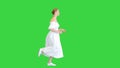 Young woman in white dress running on a Green Screen, Chroma Key.