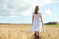 Young woman in white dress walking along on field Royalty Free Stock Photo