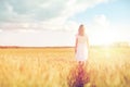 Young woman in white dress walking along on field Royalty Free Stock Photo