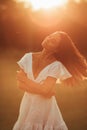 Young woman walks and enjoys in meadow at sunset Royalty Free Stock Photo