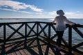Young woman in white hat standing on wooden pier Royalty Free Stock Photo