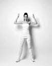 Young woman in white medical bandages, body mask wrap stands with holding hands up, holding blank space. Black and white