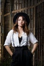 Young woman in white shirt and black hat standing near the gate. Royalty Free Stock Photo