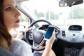 Young woman using cellphone in a car on the road Royalty Free Stock Photo