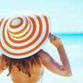 Young woman in swimsuit beach hat looking into distance . rear view Royalty Free Stock Photo