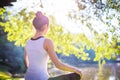 Young woman in white top practicing yoga in beautiful nature. Meditation in morning sunny day