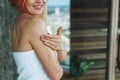 Young woman in white towel does body massage with organic natural scrab in bath, treat yourself Royalty Free Stock Photo