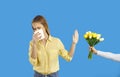 Young woman who has allergic rhinitis sneezes, blows her nose and doesn& x27;t accept flowers
