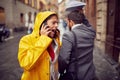 A young woman who is walking the city and speaking on the phone on a rainy day hit a passerby. Walk, rain, city Royalty Free Stock Photo