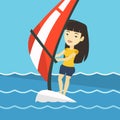 Young woman windsurfing in the sea.