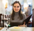 Young woman with wine looking at menu Royalty Free Stock Photo