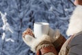 Young woman in winter coat and knitted grey mittens hold beautiful heart shaped biscuit cookies, one bitten, with white icing Royalty Free Stock Photo