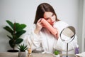 Young woman wiping her face with towel in bathroom. Royalty Free Stock Photo