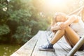 Young woman on a wooden bridge in jeans sneakers Royalty Free Stock Photo