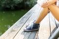 Young woman on a wooden bridge in jeans sneakers Royalty Free Stock Photo