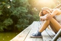 Young woman on a wooden bridge in jeans sneakers Royalty Free Stock Photo