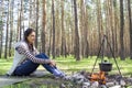 Young woman in the woods near the fire with a pot Royalty Free Stock Photo