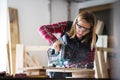 Young woman worker in the carpenter workroom. Royalty Free Stock Photo