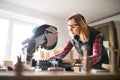 Young woman worker in the carpenter workroom. Royalty Free Stock Photo