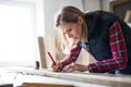 Young woman worker in the carpenter workroom.