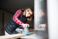 Young woman worker in the carpenter workroom. Royalty Free Stock Photo