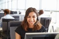 Young woman working in a call centre, looking to camera Royalty Free Stock Photo