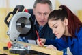 Young woman working at carpenter shop with teacher Royalty Free Stock Photo