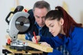 Young woman working at carpenter shop with teacher Royalty Free Stock Photo