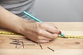 Young woman working in carpentry, marking measurements on a wooden strip with a pencil Royalty Free Stock Photo