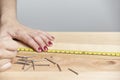 Young woman working in carpentry, marking measurements on a wooden strip with a pencil Royalty Free Stock Photo