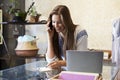 Young woman working in clothing store takes phone enquiry