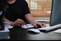 Woman working with computer and wiring information on notebook.