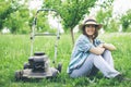 Young woman working in garden trimming grass with lawn mower Royalty Free Stock Photo