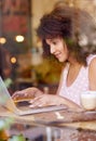 Young woman working on her laptop in a coffee shop Royalty Free Stock Photo