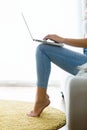 Young woman working with her laptop sitting in the sofa at home. Royalty Free Stock Photo