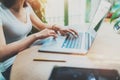 Young woman working at home on modern computer.Girl typing on laptop keyboard sitting at the wooden table.Concept of Royalty Free Stock Photo