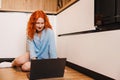 Young woman working from home office. Freelancer using laptop and the Internet for shopping online. Happy girl smiling Royalty Free Stock Photo