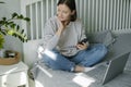 Young woman working from home office. Freelancer using laptop, phone and the Internet Royalty Free Stock Photo