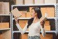 Young woman working at home for packeting parcel boxes to shipping delivery services to customer Royalty Free Stock Photo