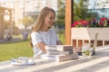 Young woman working at laptop with books outside in city park. Happy and smiling student girl using computer. Distance Royalty Free Stock Photo