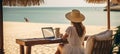 Young woman working on laptop computer by the sea freelancer, travel, and vacation concept