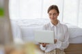 Young woman working on laptop computer while sitting on floor at the bedroom. Royalty Free Stock Photo