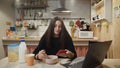 Young woman working laptop computer, using smartphone and eats Corn Flakes Cereal at home kitchen. Royalty Free Stock Photo