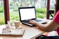 Young  woman working  laptop computer on wood desk in coffee shop.,Empty notebook Royalty Free Stock Photo