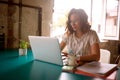 A young woman is working on a laptop while sitting at the desk in the office Royalty Free Stock Photo