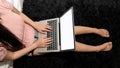 A young woman working with a laptop sitting on the floor in the bedroom with a top view Royalty Free Stock Photo