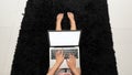 A young woman working with a laptop sitting on the floor in the bedroom with a top view Royalty Free Stock Photo