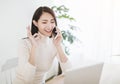 Young woman working on  laptop and talking on the phone in the home office Royalty Free Stock Photo